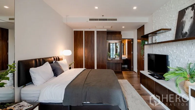 Condominium for sale in Khlong Toei, Bangkok - Spacious bedroom with king bed, wardrobes, dressing area, and ensuite access.