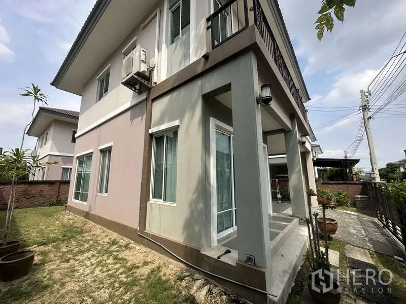 Detached House for sale in Sai Mai, Bangkok - Side porch with pillars, sliding doors and walkway to the garden.