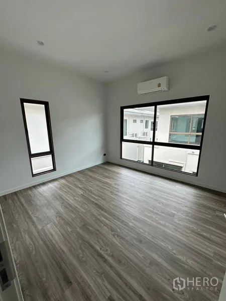 独立式住宅 出租在Bang Kapi, Bangkok - 宽敞卧室，设大窗与壁挂空调，俯瞰邻里景致。