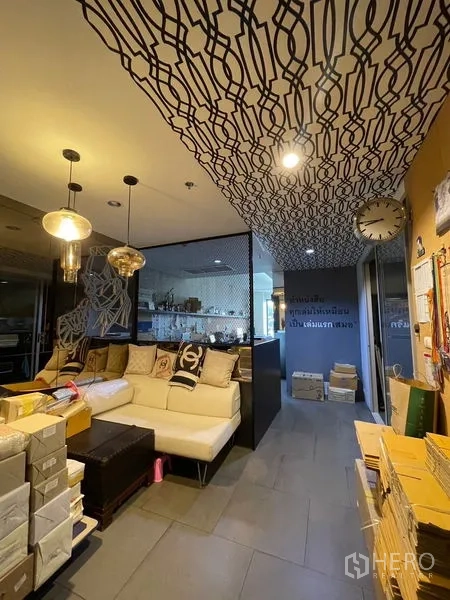 办公空间 出租在Phaya Thai, Bangkok - 入口与接待区，几何图案天花、挂钟和隔断旁的沙发。