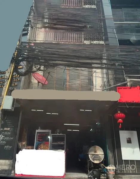 อาคารพาณิชย์ ขายในWatthana, Bangkok - ด้านหน้าตึกแถวติดถนนในเขตวัฒนา กรุงเทพฯ หน้าร้านเปิดโล่ง มีตู้กระจก โคมสีแดง และสายไฟพาดหน้าตึกจำนวนมาก