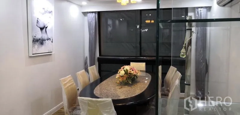 Condominium for rent in Khlong Toei, Bangkok - Dining area with oval granite-top table, six chairs and glass display cabinet.
