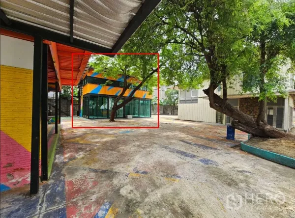 Warehouse for rent in Watthana, Bangkok - Large hardstand area facing a two-storey glass building and an adjacent office block.
