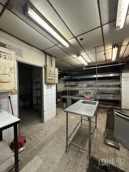 Retail Space for rent in Yan Nawa, Bangkok - Kitchen prep area with stainless tables, shelving and brick floor.
