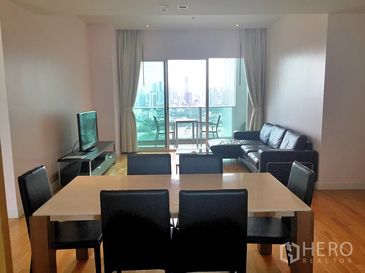 Condominium for rent in Khlong Toei, Bangkok - Open-plan living and dining area with leather sectional sofa, TV console and balcony city view.