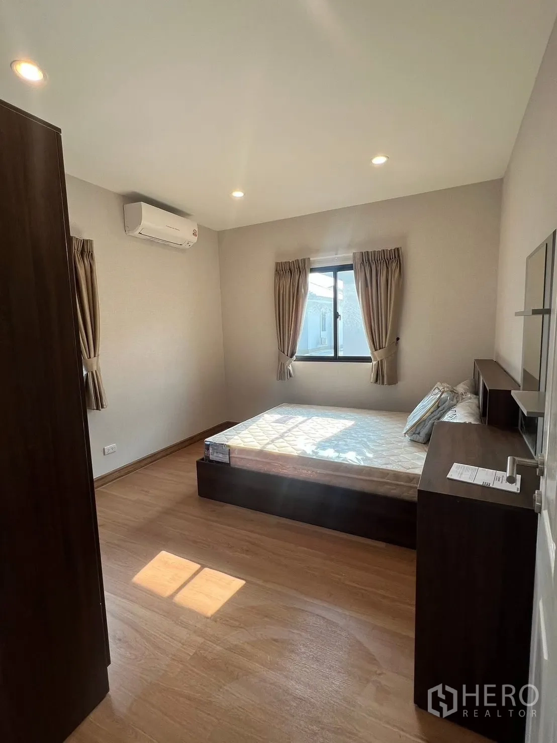 บ้าน ให้เช่าในBang Phli, Samut Prakan - ห้องนอนสว่างพื้นไม้ มีเตียง ผ้าม่าน และเครื่องปรับอากาศ