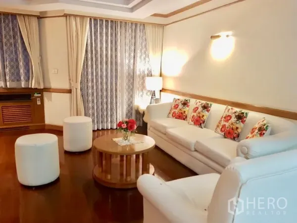 Condominium for rent in Watthana, Bangkok - Cozy living room with white sofa set, drapes and soft ambient lighting.