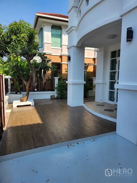 Detached House for rent in Bang Kapi, Bangkok - Shaded front patio with tiled terrace, greenery and arched porch.