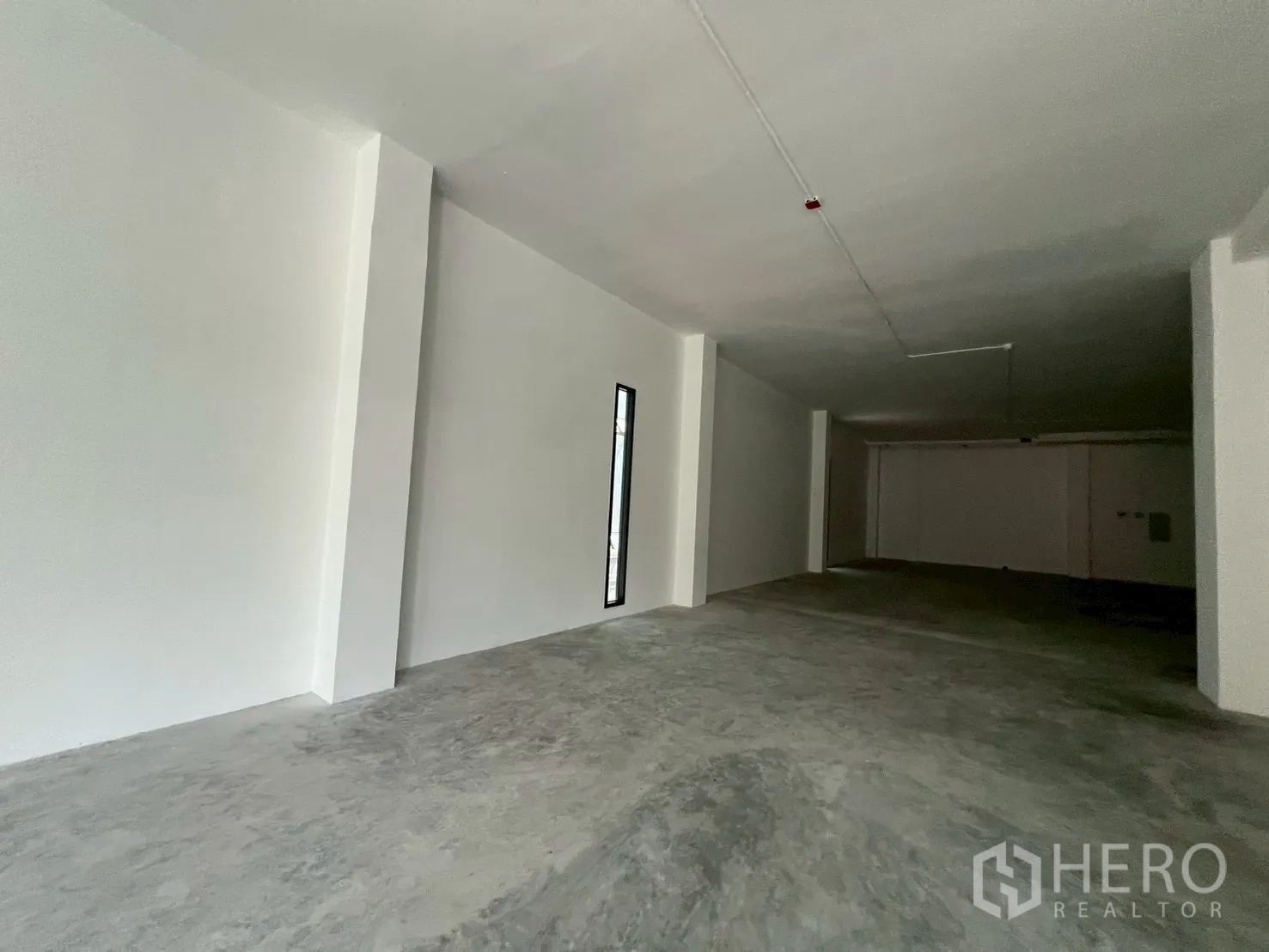 零售空间 for rent in Khlong Toei, Bangkok - 开间深、白色墙面与未铺装混凝土地面，适合自定义装修。