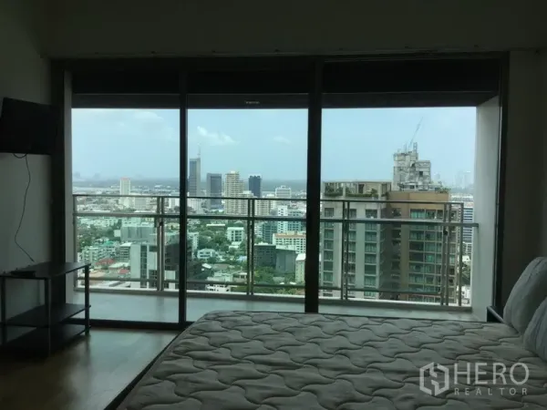 公寓 出租在Watthana, Bangkok - 卧室整面落地玻璃门通向阳台，视野开阔。