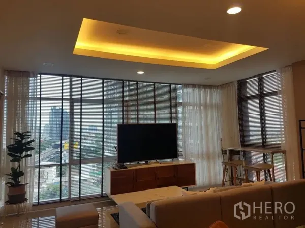公寓 出租或出售在Bang Na, Bangkok - 客厅设落地窗与天幕灯，可欣赏城市景观，配电视柜。