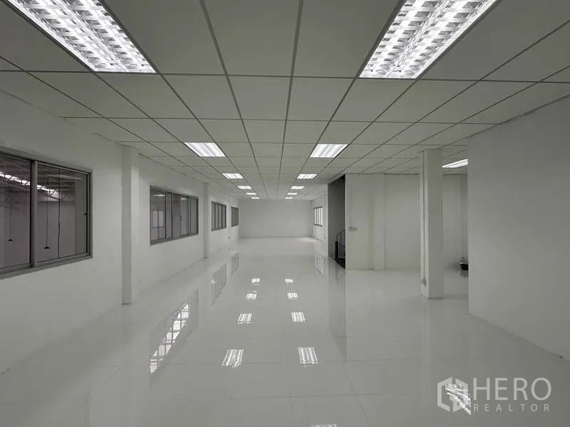 Factory for rent in Khlong Luang, Pathum Thani - Long office corridor with interior windows providing views over the warehouse floor.