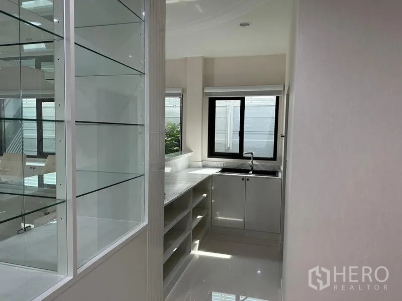 Detached House for sale in Saphan Sung, Bangkok - Bright pantry with marble counters, open shelving and a corner sink beside windows.