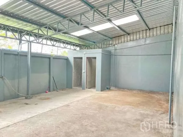 Factory for rent in Samut Prakan - Covered yard with steel truss roof, two restrooms and a concrete floor for utilities and washing.