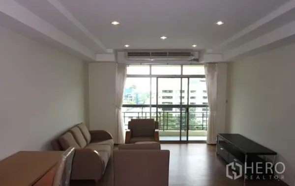 Condominium for rent or sale in Watthana, Bangkok - Bright living room with sofa set, recessed lights, and balcony with city view.