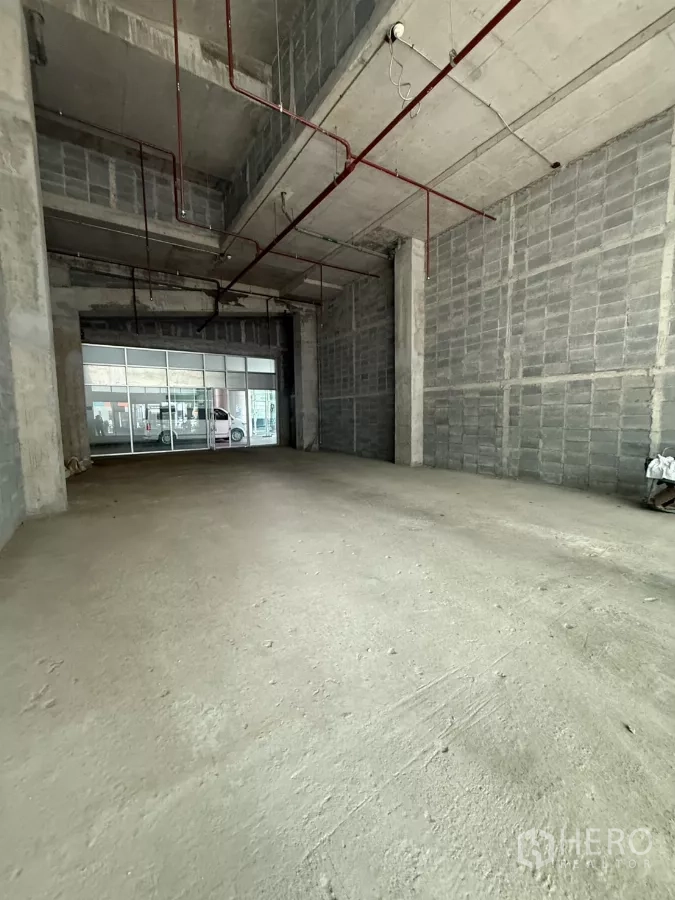 零售空间 出租在Bang Rak, Bangkok - Bang Rak 未装修挑高商铺，外露红色消防管线，临街大面积玻璃门面。