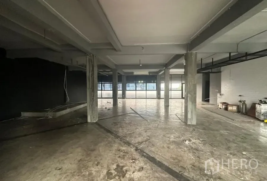 Retail Space for rent - Wide view of the vacant retail floor showing structural beams and expansive glazing for natural light.