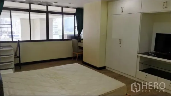 公寓 出租或出售在Khlong Toei, Bangkok - 明亮卧室，整面落地窗、嵌入式衣柜、书桌，可见城市景观，位于Nana一带公寓。
