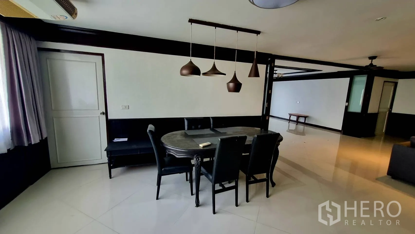 Condominium for rent in Watthana, Bangkok - Dining table for six under statement pendant lights.