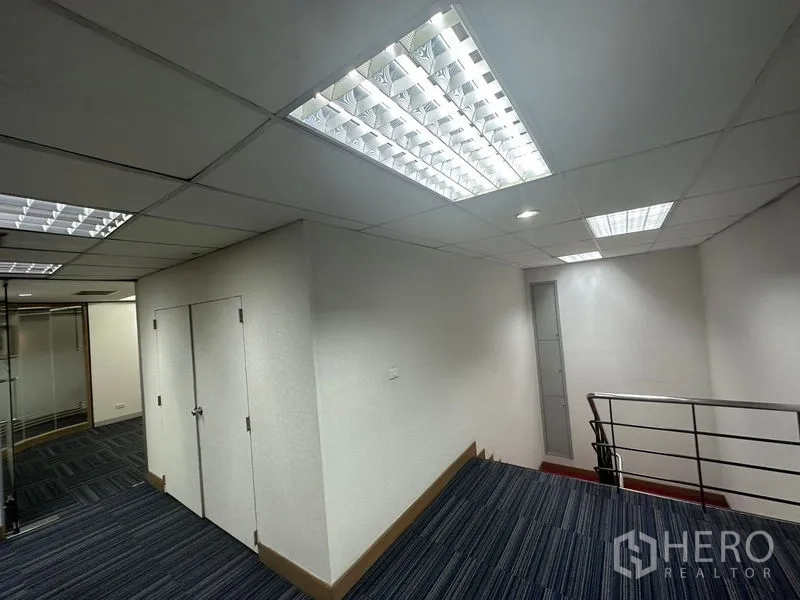 办公空间 出租在Khlong Toei, Bangkok - 明亮走廊，吊顶灯具与金属楼梯扶手
