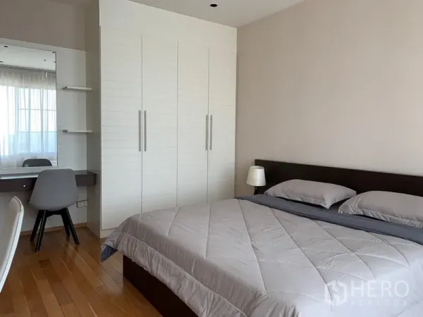 Condominium for rent in Khlong Toei, Bangkok - Spacious bedroom with king bed, large white wardrobe and dressing table.