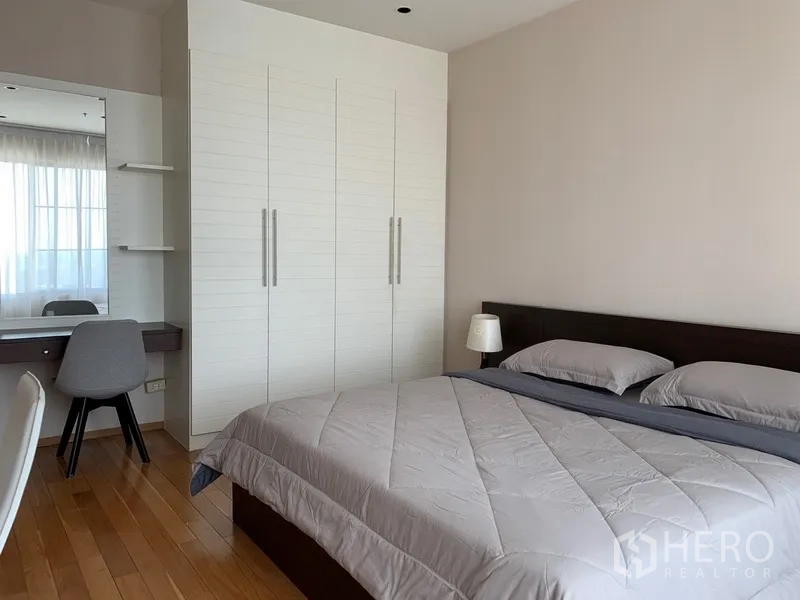 Condominium for rent in Khlong Toei, Bangkok - Spacious bedroom with king bed, large white wardrobe and dressing table.