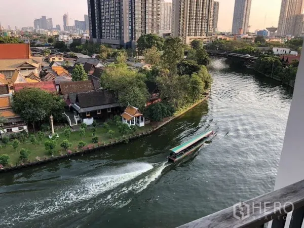 公寓 出租在Watthana, Bangkok - 运河景观，长尾船、绿树与城市高楼。