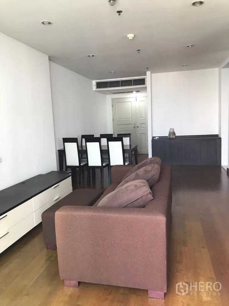 公寓 出租在Watthana, Bangkok - 开放式客餐厅，棕色沙发与餐桌，木地板