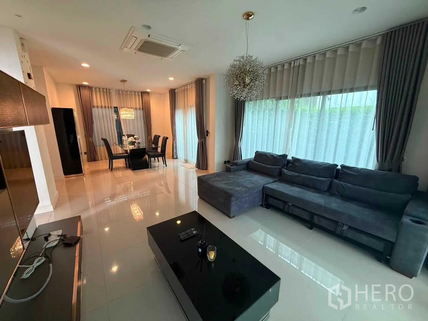Detached House for rent in Bang Kapi, Bangkok - Bright living room with a large L-shaped sofa and wide windows.