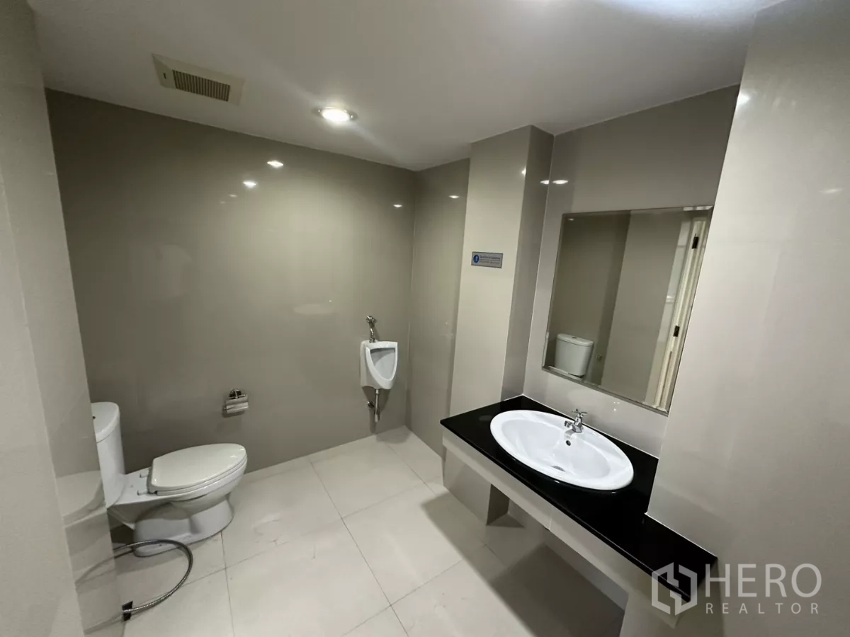 สำนักงาน ให้เช่าในWatthana, Bangkok - ห้องน้ำสมัยใหม่ มีโถสุขภัณฑ์ โถปัสสาวะ กระจกบานใหญ่ และอ่างล้างหน้า.