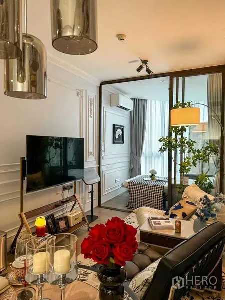 Condominium for rent - Bright living room with TV console, glass partition to the bedroom, floor lamp and indoor plants at Fynn Asoke.