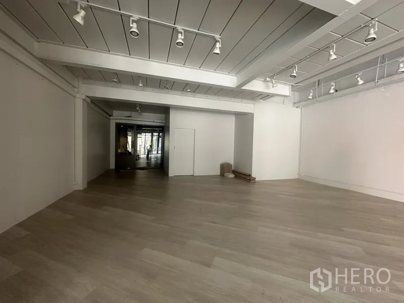 Retail Space for rent in Khlong Toei, Bangkok - Deep retail area with white walls, spotlight tracks and pale timber floors.