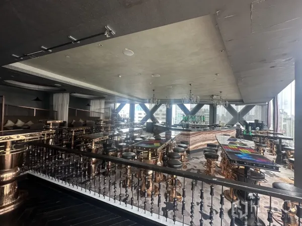 Retail Space for rent in Khlong Toei, Bangkok - Wide bar hall with a marble counter and skyline views through large windows.