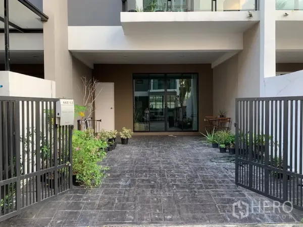 联排别墅 出租在Khlong Toei, Bangkok - 带大门的入户车道和有顶车位，通向推拉玻璃门。