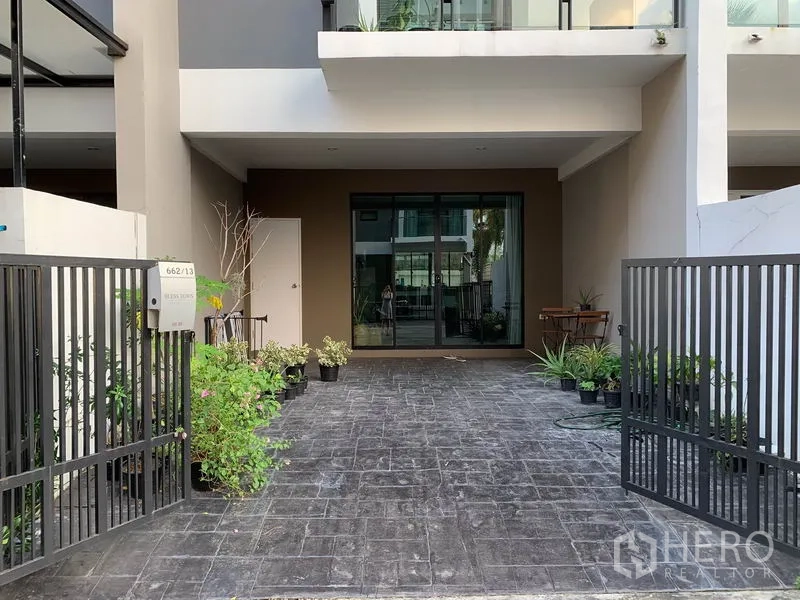 联排别墅 出租在Khlong Toei, Bangkok - 带大门的入户车道和有顶车位，通向推拉玻璃门。