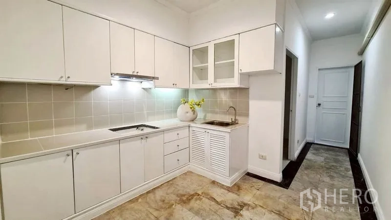公寓 for rent in Watthana, Bangkok - 白色一字型厨房，带橱柜、灶台与水槽。
