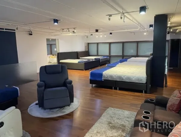 零售空间 出租 - 明亮展厅楼层，多个展示区与休闲椅，射灯与木地板