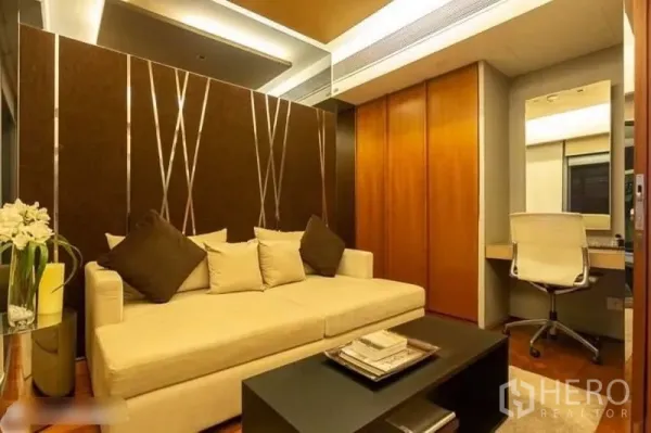Condominium for rent in Yan Nawa, Bangkok - Cozy lounge or study with cream sofa, accent wall, built‑in desk and full‑height storage.