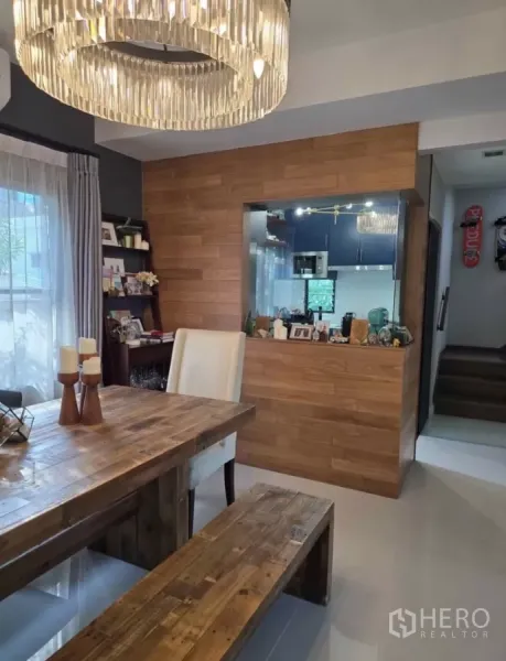 Detached House for rent in Bang Phli, Samut Prakan - Dining room view toward kitchen pass-through with wood accent wall and shelving