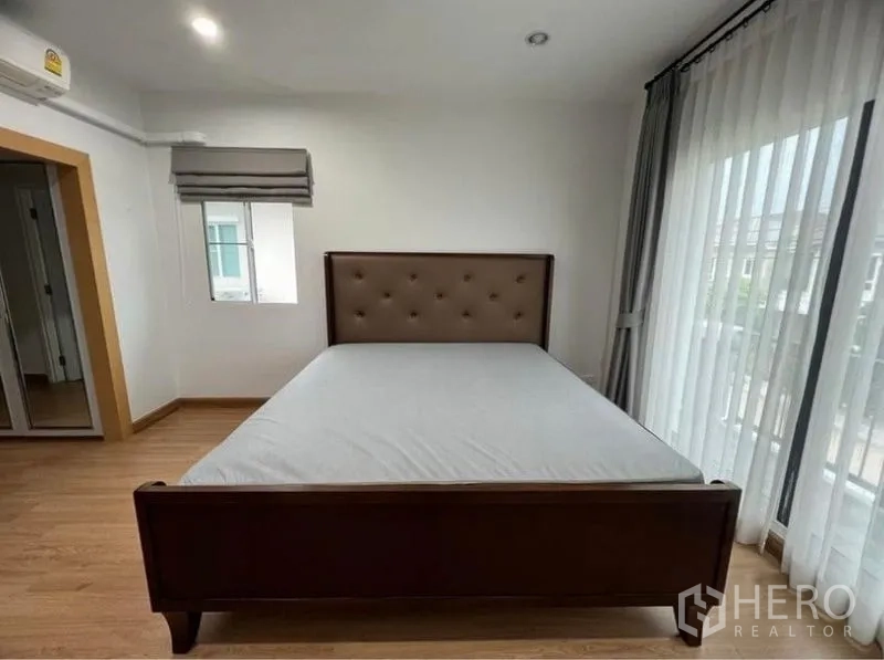 บ้าน ให้เช่าในSuan Luang, Bangkok - ห้องนอนหลัก เตียงบุนวมและประตูกระจกออกระเบียง