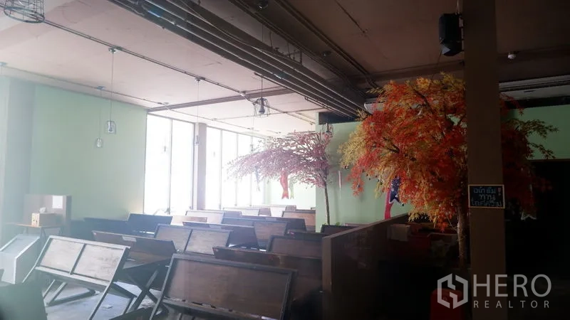 Retail Space for rent in Watthana, Bangkok - Spacious dining-style area with bench seating, large windows, and an industrial open ceiling.