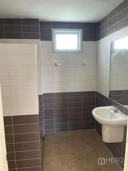 Warehouse for rent in Samut Sakhon - Tiled restroom with sink, mirror and a small window for ventilation inside the warehouse.