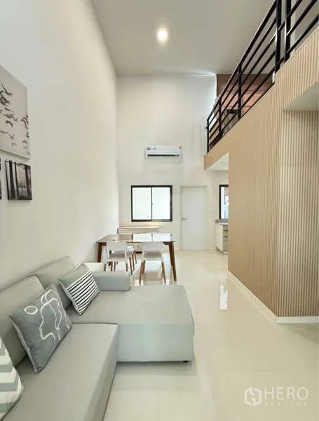 Townhouse for rent in Bang Phli, Samut Prakan - Open-plan living and dining area with high ceiling and loft above.