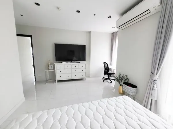 公寓 出售在Watthana, Bangkok - 主卧一角，带抽屉柜、大屏电视、书桌与纱帘