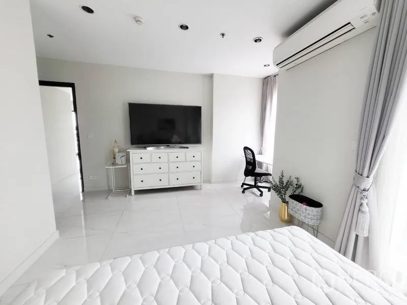 公寓 出售在Watthana, Bangkok - 主卧一角，带抽屉柜、大屏电视、书桌与纱帘