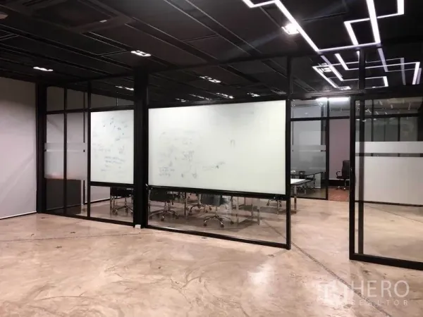 Office Space for rent in Bang Na, Bangkok - Glass-partitioned meeting rooms with writable whiteboard walls and geometric LED ceiling lights.