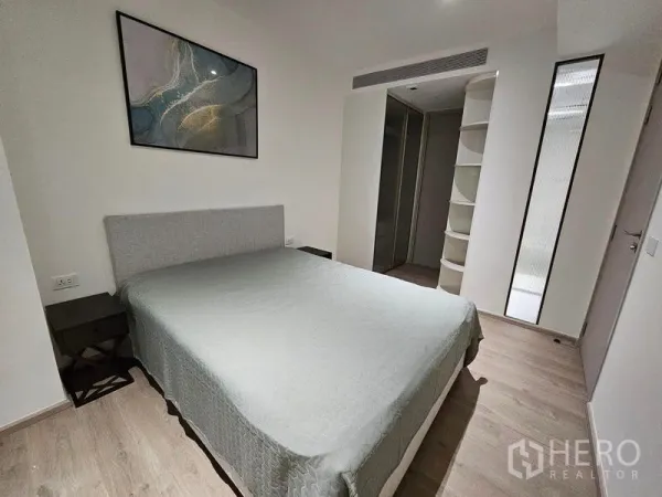 Condominium for rent or sale - Primary bedroom with built-in storage, bedside tables, and neutral decor.