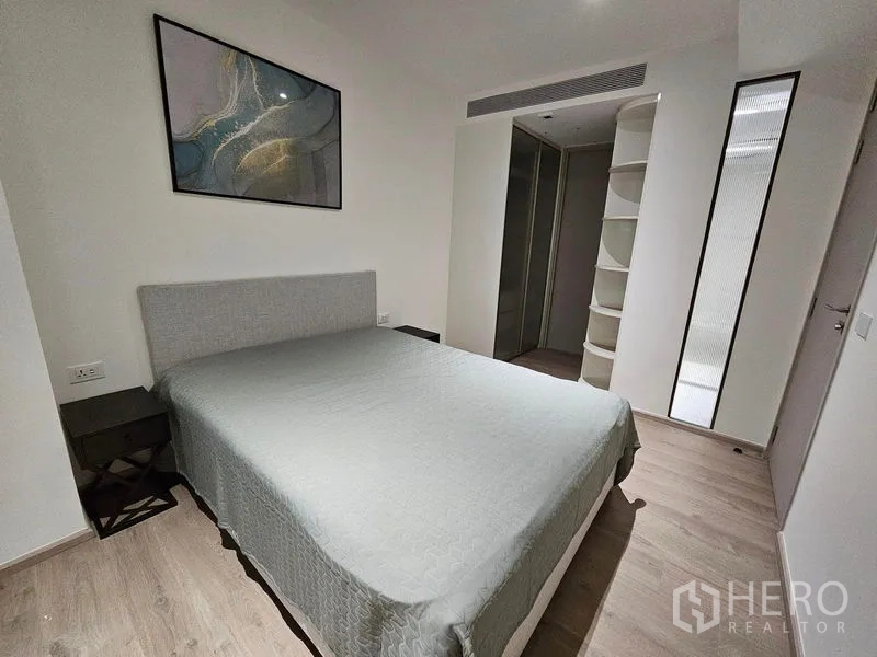 Condominium for rent or sale - Primary bedroom with built-in storage, bedside tables, and neutral decor.