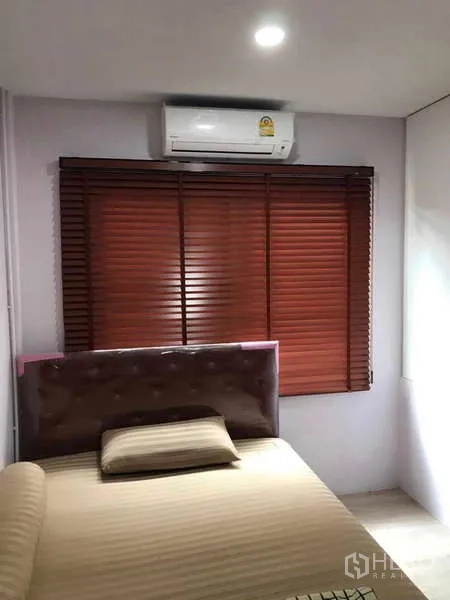 Townhouse for rent - Second bedroom with air-conditioner, window blinds and upholstered bed.