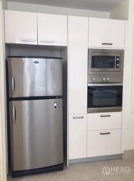 Condominium for rent in Watthana, Bangkok - Built-in pantry wall featuring stainless refrigerator, microwave and oven.